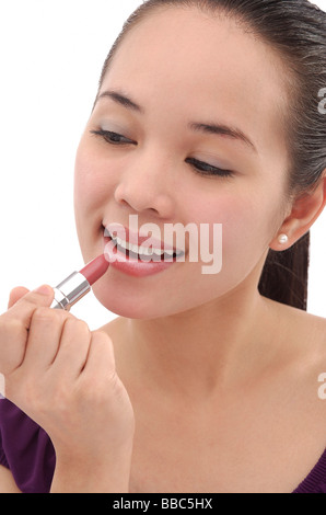Junge Frau Auftragen von Lippenstift Stockfoto