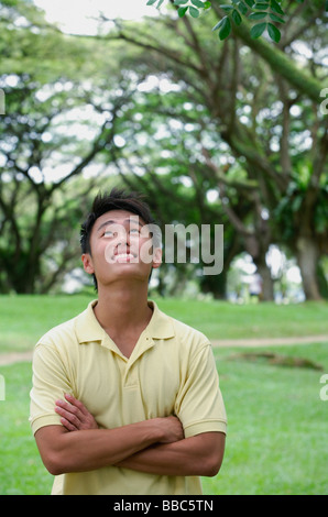 Junger Mann mit verschränkten Armen und nachschlagen Stockfoto