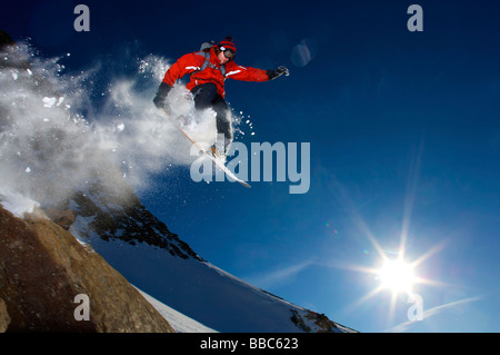 Snowboarder von einem Felsen springt. Stockfoto