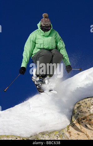 Skifahrer von einem Felsen springt. Stockfoto