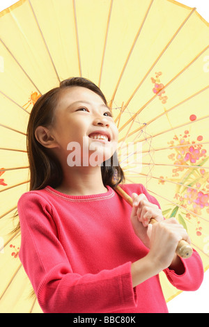 Mädchen halten gelben Regenschirm Stockfoto