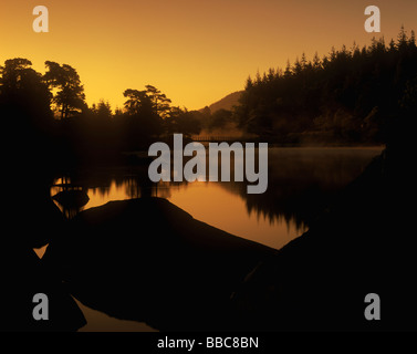 Goldenen Sonnenaufgang am nebligen Llynau Mymbyr eines Snowdonias malerische Seen. Blick über, Plas y Brenin Stockfoto