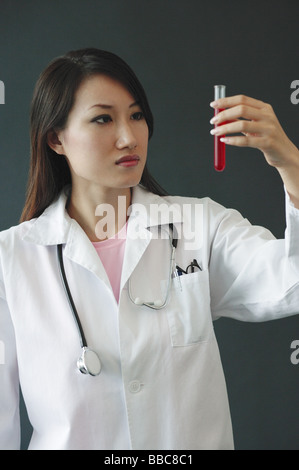 Ärztin im Reagenzglas, ernsten Ausdruck suchen Stockfoto