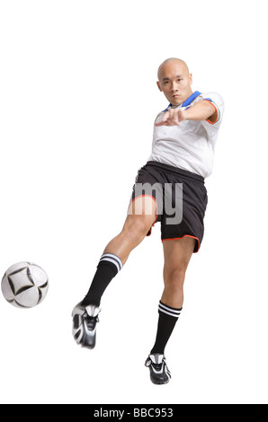 Junger Mann im Fußball Uniform, treten ball Stockfoto