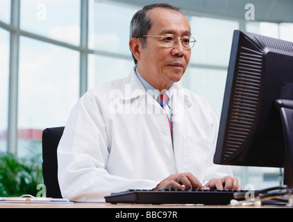 Arzt in Büro, Desktop-Computer verwenden Stockfoto