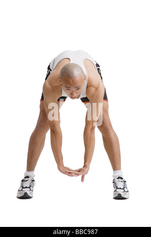 Junger Mann beugte sich über tun Dehnübungen Stockfoto