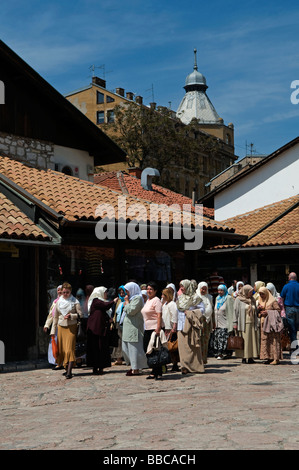 Muslimische bosniakische Frauen, die im Distrikt Bascarsija, dem Marktsektor der Altstadt in Sarajevo, Bosnien und Herzegowina, spazieren gehen Stockfoto