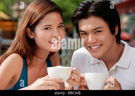 Paar im Café mit Kaffee, lächelnd in die Kamera Stockfoto
