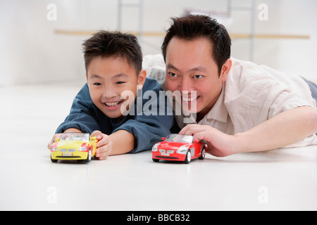 Vater und Sohn auf Boden, spielen mit Spielzeug-Autos Stockfoto