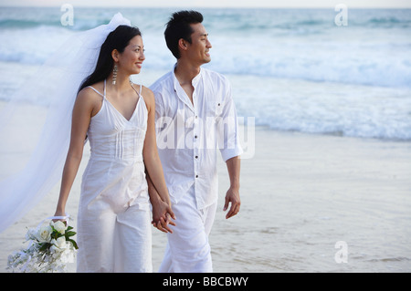 Brautpaar am Strand zu Fuß, Hände halten, suchen entfernt Stockfoto