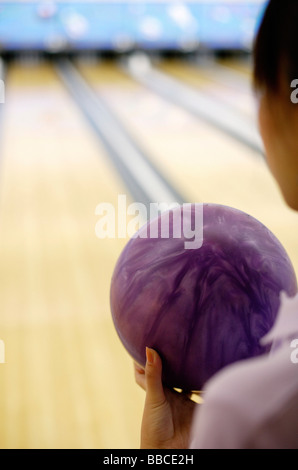 Frau mit Bowling-Kugel, über die Schulter-Blick Stockfoto