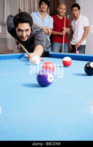 Mann, Billard, andere Männer zusehen im Hintergrund Stockfoto