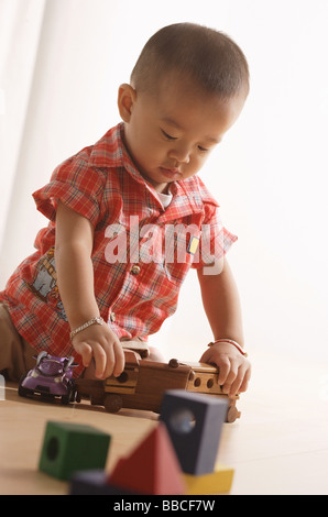 Kleiner Junge spielt mit Spielzeugeisenbahn Stockfoto