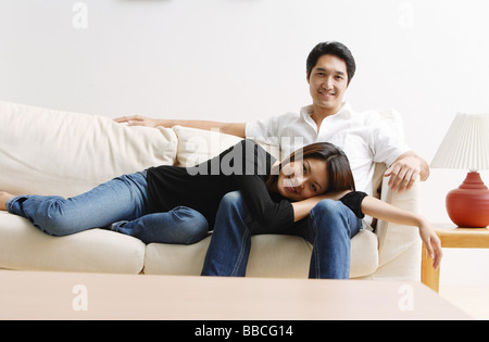 Paar auf Sofa, Frau liegt auf mans Schoß, Blick in die Kamera Stockfoto