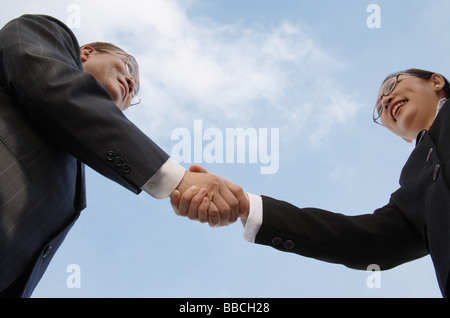 Unternehmer und Unternehmerin, die Hände schütteln, niedrigen Winkel Ansicht Stockfoto