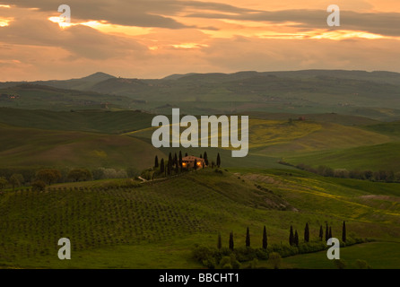 Typisch toskanische Villa im frühen Morgenlicht mit Sonnenaufgang über den sanften Hügeln des Val D'orcia, Toskana, Italien. Stockfoto