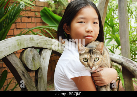 Mädchen halten Katze, Blick in die Kamera Stockfoto