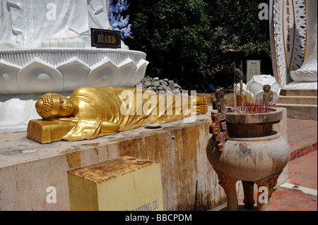 Liegender Buddha zu Füßen der Statue von A Di Da oder Amitabha Buddha der Vergangenheit. Ta Cu Berg, Vietnam Stockfoto