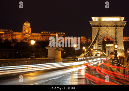 Verkehr an der Kettenbrücke und dem königlichen Palast von Buda in Budapest, Ungarn bei Nacht Stockfoto