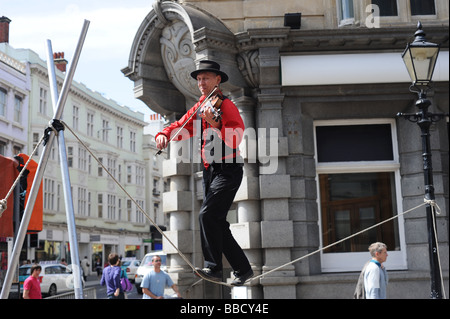 Ein Mann spielt Geige, während Balancieren auf einem Drahtseil Teil von Brighton Festival 2009 Stockfoto