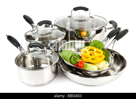 Edelstahl-Töpfe und Pfannen isoliert auf weißem Hintergrund mit Gemüse Stockfoto