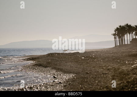 Fischer, die an einem langen ausgedehnten Strand allein Stockfoto