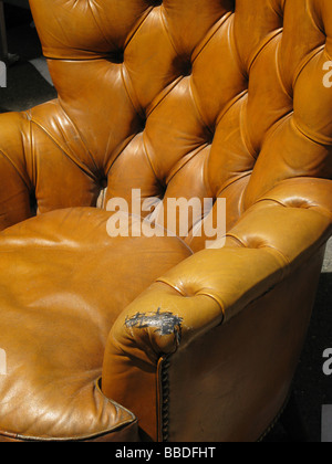 alte beschädigte Ledersessel in der Straße in der Sonne Stockfoto