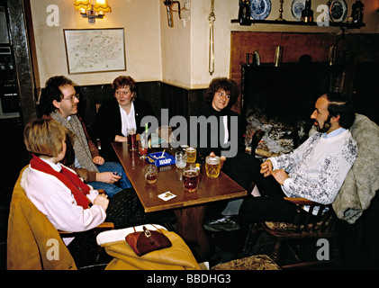 Gruppe von Freunden in der Kneipe sitzen und genießen ein Getränk und einen Chat, England, der 1980er Jahre. Stockfoto
