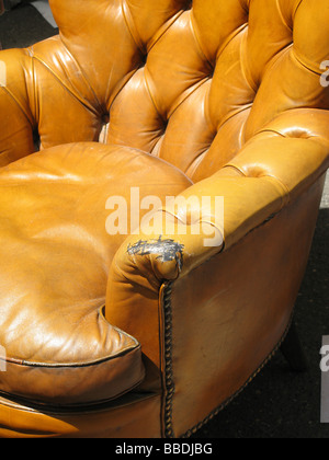 alte beschädigte Ledersessel in der Straße in der Sonne Stockfoto