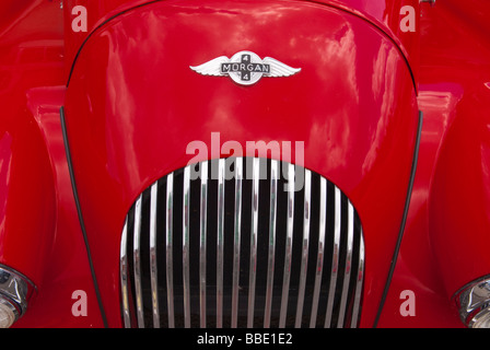 Eine Nahaufnahme der Bonnett und Grill von einem klassischen Morgan 4 Oldtimer Sportwagen zeigt das Abzeichen Logo des roten Fahrzeugs Stockfoto