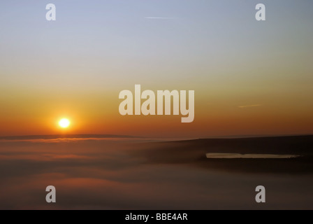 Ein roter Sonnenuntergang über dem Berg Nebelmeer Läppen der Rand des Wasserbeckens in der Pennines, westlich von Halifax, Großbritannien Stockfoto