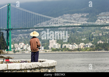 Fischer die Morgenfischen im Burrard Inlet im Stanley Park mit Blick auf die Lions Gate Bridge genießen Stockfoto