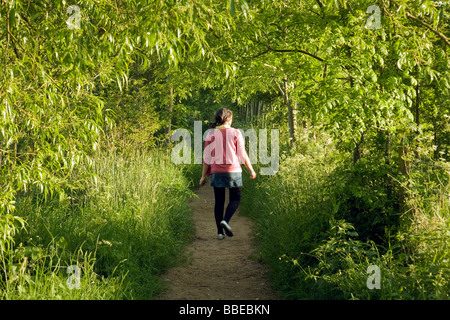 Ein Teenager-Mädchen gehen in den Wald auf einem Pfad allein, Wallingford, Oxfordshire, Vereinigtes Königreich Stockfoto