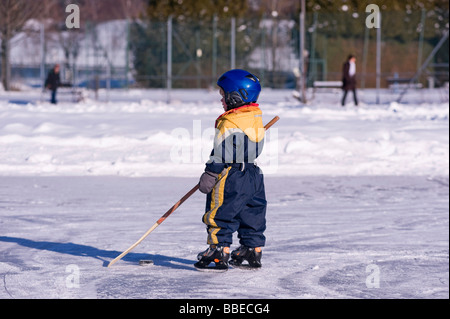 Kleiner Junge spielt Hockey auf einem zugefrorenen Teich, Fuschlsee, Salzburger Land, Österreich Stockfoto