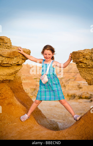 Kleines Mädchen stehend zwischen Felsen in Badlands Nationalpark, South Dakota, USA Stockfoto