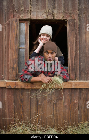 Porträt des Paares gelehnt aus Scheune Fenster auf einem Bauernhof in Hillsboro, Oregon, USA Stockfoto