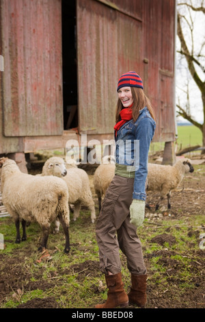 Teenager-Mädchen mit einer Schafherde auf einer Farm in Hillsboro, Oregon, USA Stockfoto