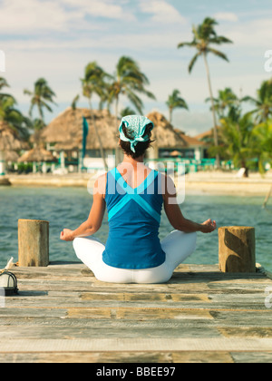 Frau beim Yoga am Dock in Belize Stockfoto