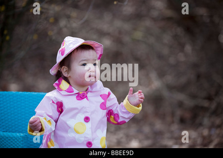 Kleines Mädchen im Park tragen Regenmantel und Hut, Bethesda, Maryland, USA Stockfoto