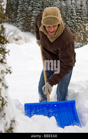 Mann Schaufeln Schnee, Hof Bei Salzburg, Österreich Stockfoto