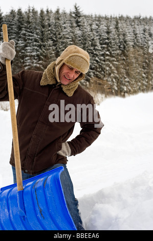 Mann Schaufeln Schnee, Hof Bei Salzburg, Österreich Stockfoto