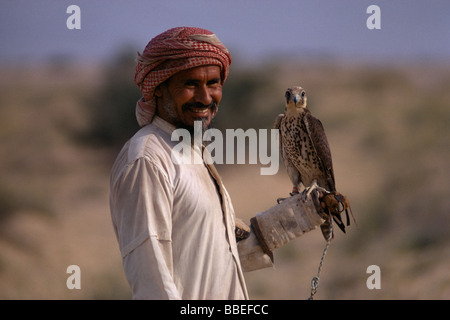 Saudi-Arabien Nahost Golf Königreich Staat Beduinen Falknerei Beduinen Mann Betrieb Falke an seinem Handgelenk. Stockfoto