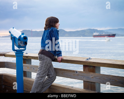 Junge auf der Suche über Wasser vom Pier, San Francisco, Kalifornien, USA Stockfoto