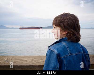 Junge auf der Suche über Wasser vom Pier, San Francisco, Kalifornien, USA Stockfoto