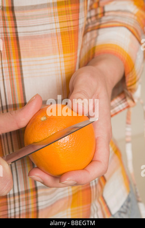 Hände, Peeling Orange Stockfoto