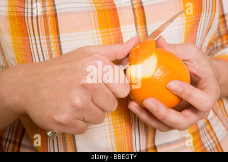 Hände, Peeling Orange Stockfoto