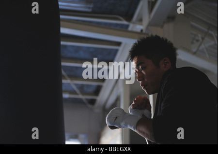 Japanischer Boxer üben mit Boxsack Stockfoto