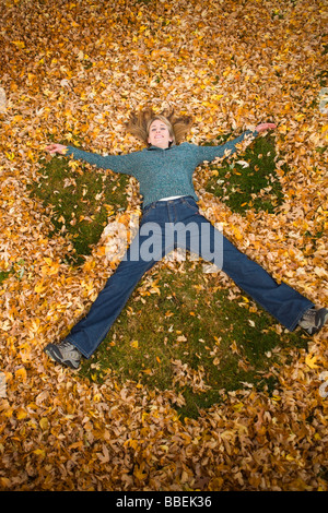 Frau spielt in Blätter im Herbst, Bend, Oregon, USA Stockfoto