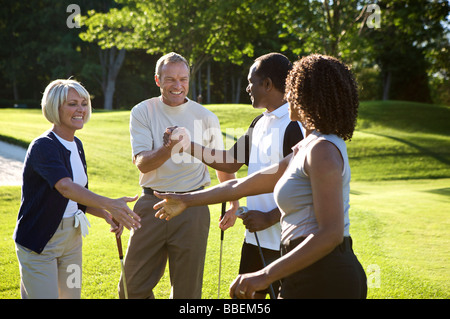 Paare, Händeschütteln auf Golfplatz Stockfoto
