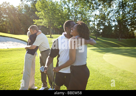 Paare, die umarmt auf Golfplatz Stockfoto
